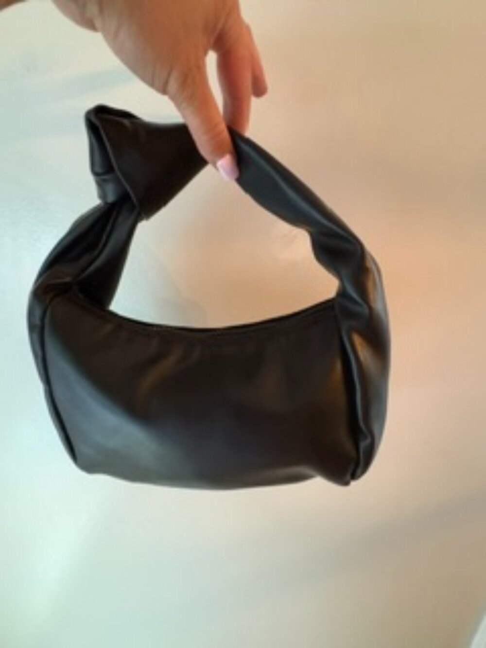Very cool knotted strap black purse. Faux leather.